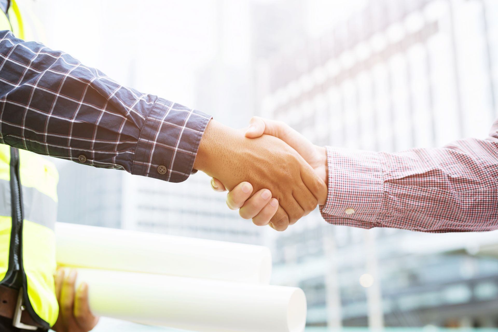 Close up of a engineering male holding document plan Construction project worker hand shake between two business man, Represents is good project success approve, congratulations. outdoor of building. Close up of a engineering male holding document plan Construction project worker hand shake between two business man, Represents is good project success approve, congratulations. outdoor of building.